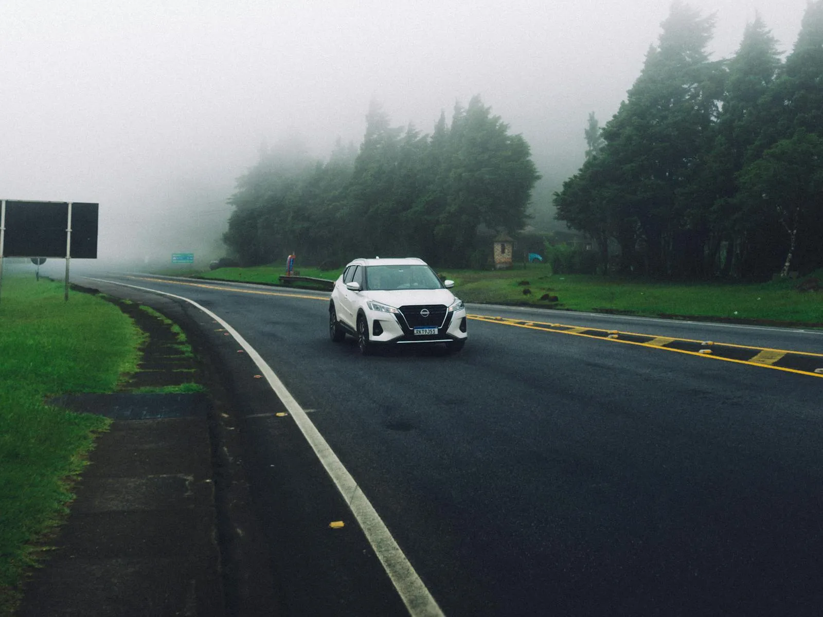 Fog over White Nissan Kicks on Road under Fog