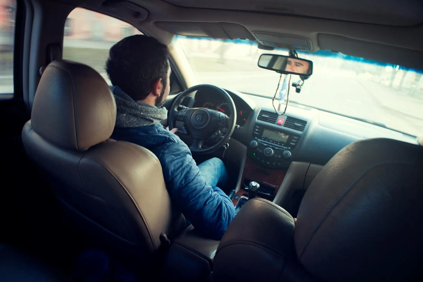 Man Wearing Blue Jacket Sitting Inside Car While Driving