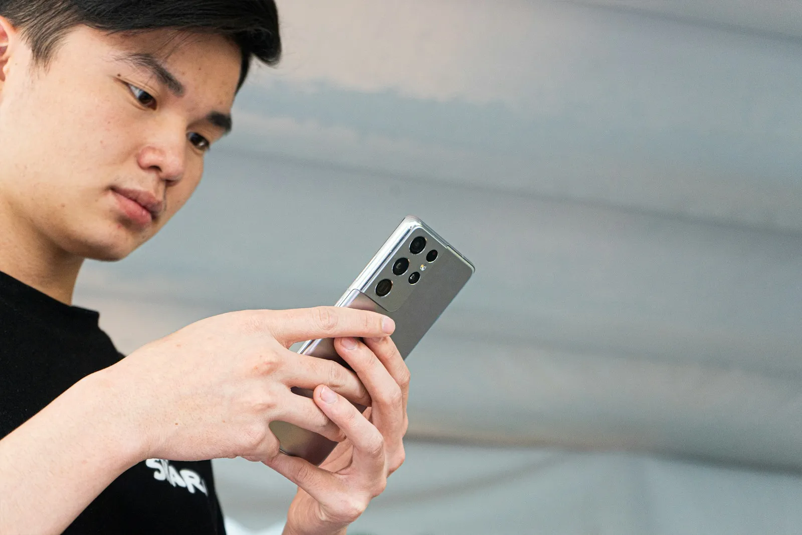 woman in black and white shirt holding silver iphone 6