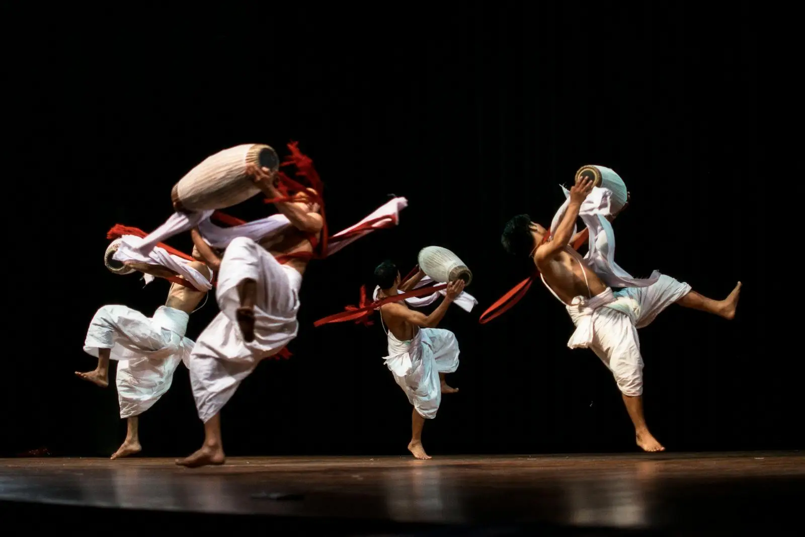 Group of Men Holding Drums Performing on Stage