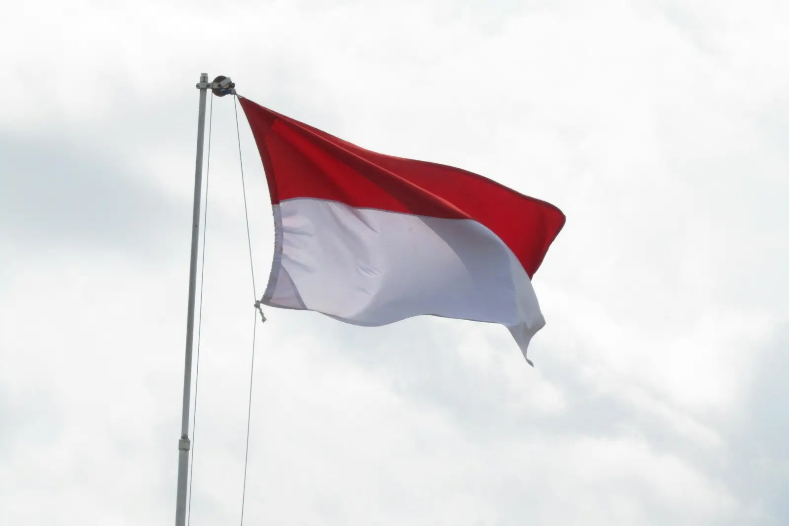 red and white flag under white clouds