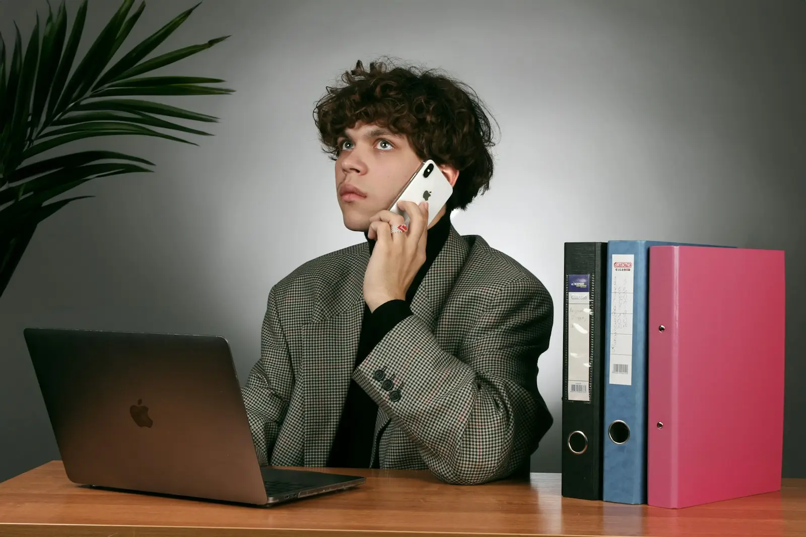 a man sitting at a desk talking on a cell phone