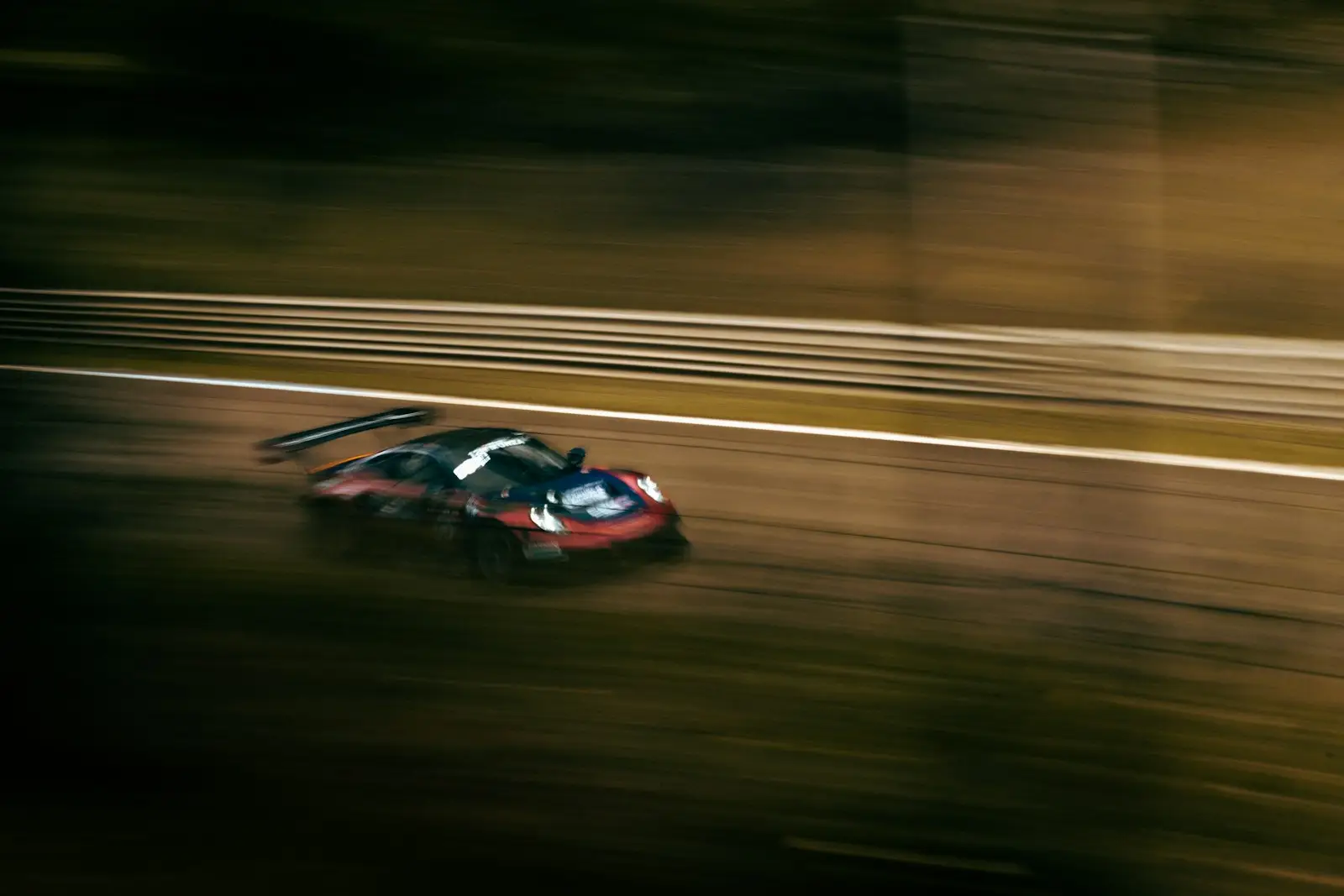 a blurry photo of a car driving down a track