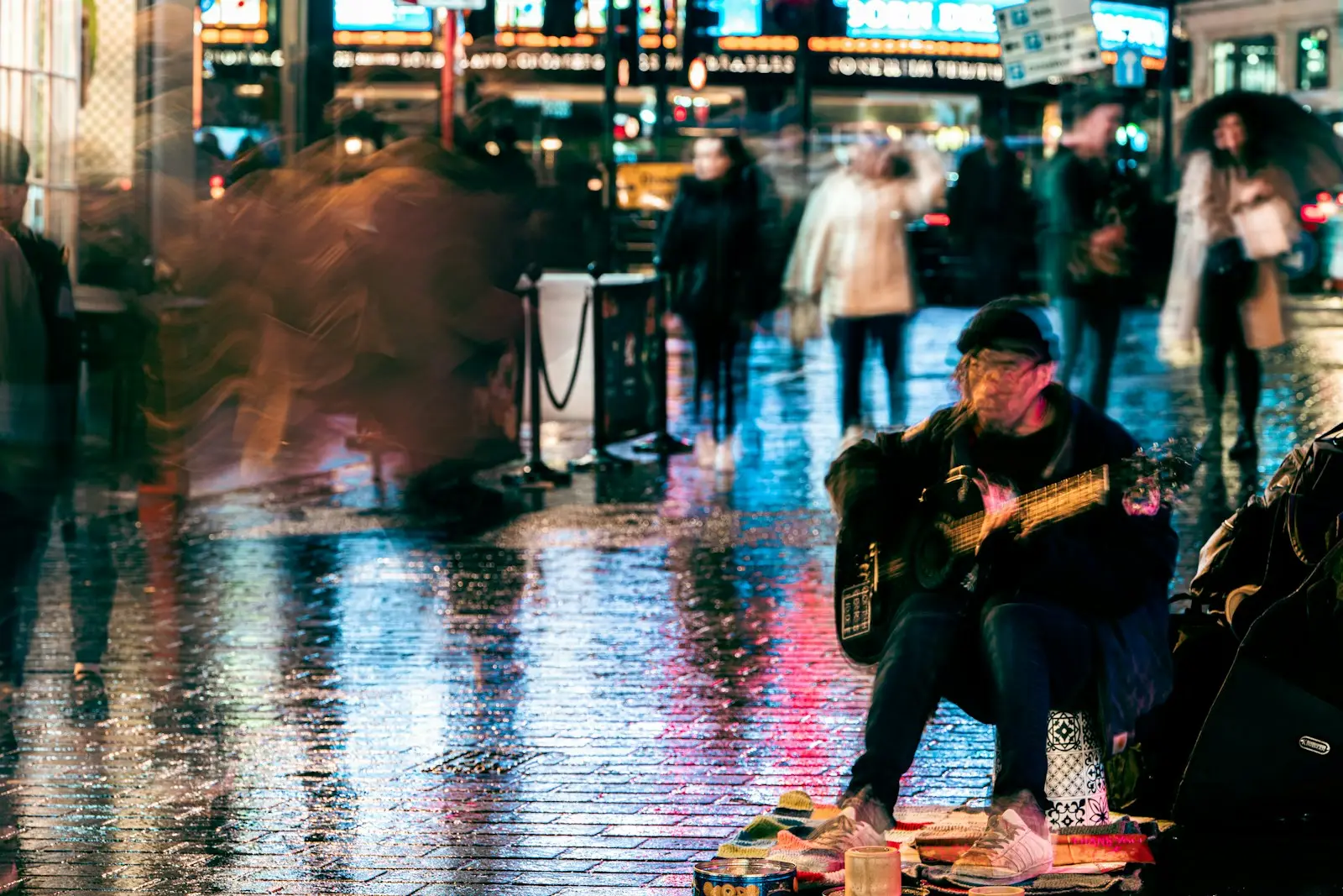 a man sitting on the ground playing a guitar