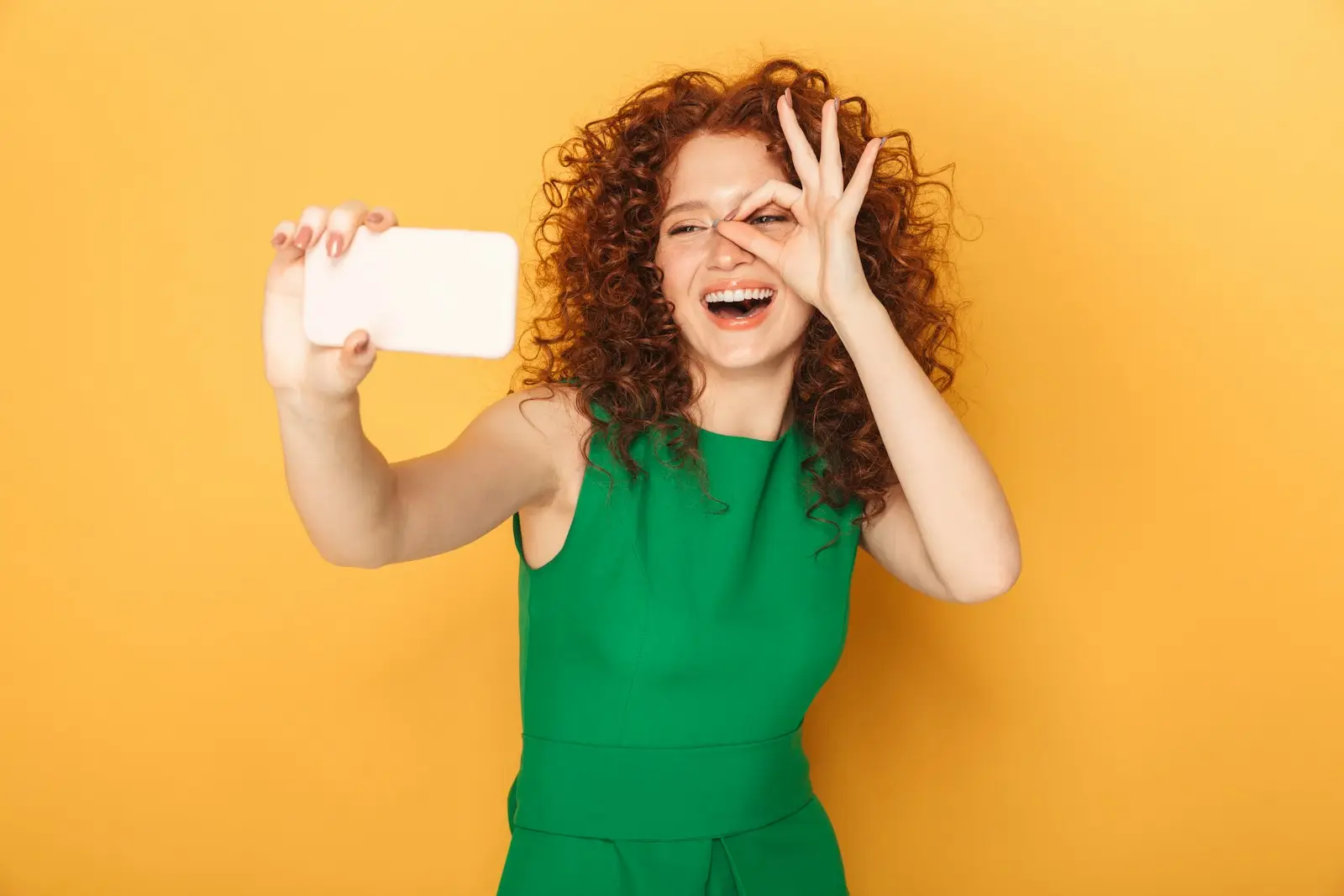 a woman in a green dress holding a white object